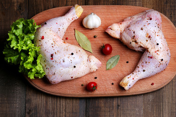 A flavored raw chicken thigh on the table before preying top view.