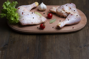 A flavored raw chicken thigh on the table before preying with copy space.