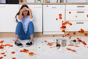 Woman Sitting On Kitchen Floor With Spilled Food