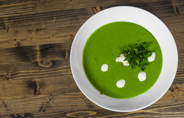 Spinach cream soup in bowl on a wooden background. with copy space. top view
