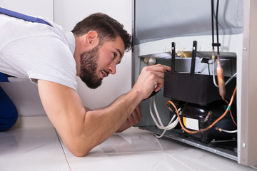 Technician Repairing Refrigerator