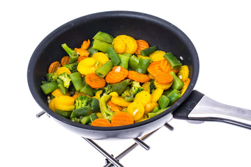 Stewed vegetables in frying pan over white background