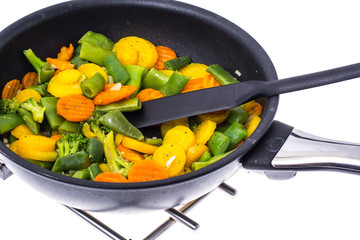 Stewed vegetables in frying pan over white background