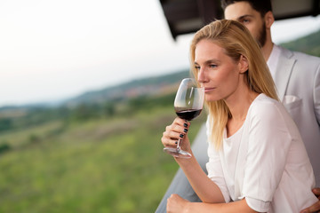 People sampling and tasting wines in vineyard