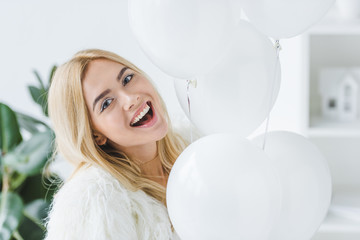 cheerful woman with white balloons
