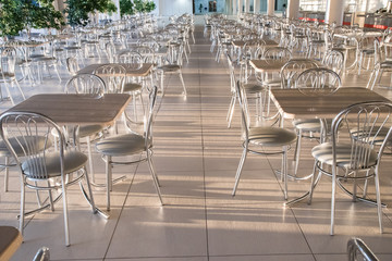 Metal chairs with high backs and tables in the morning sun in the cafe