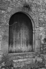 Wooden door on rock wall in a french abbey