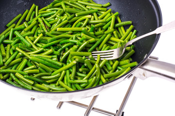 Fried pods of green beans in frying pan