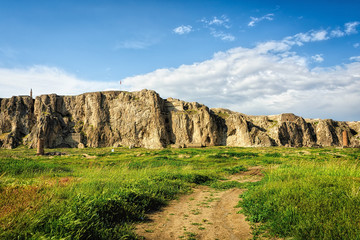Green landscape with blue sky and fluffy clouds
