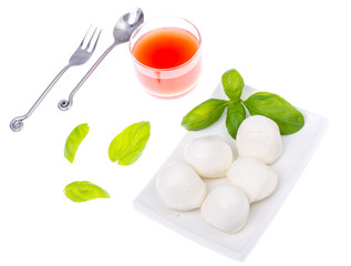 Mozzarella, basil and tomato juice on white background