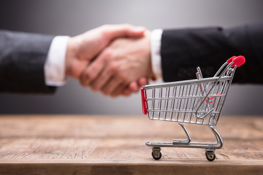 Close-up Of Shopping Cart On Wooden Table - Powered by Adobe