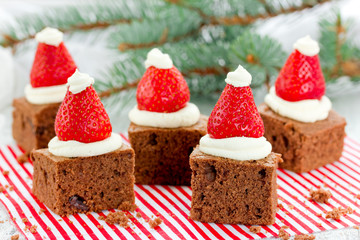 Santa hat brownie, Christmas dessert, chocolate pieces with strawberry and cream