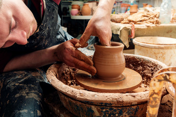 Potter at work. Workshop. Hands of a potter, creating an earthen jar on the circle