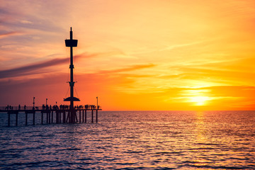 People on Brighton Jetty at sunset