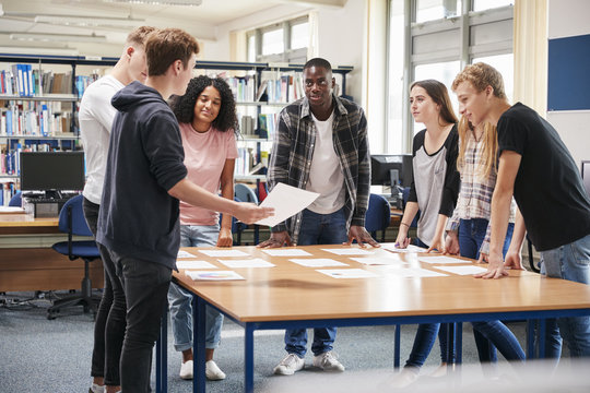 Group Of College Students Collaborating On Project In Library