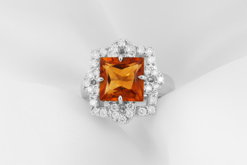 White gold ring with citrine and diamonds on soft white background
