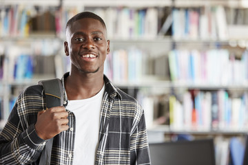 Portrait Of Male Student Standing In College Library