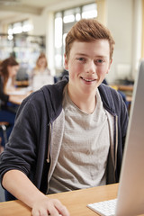 Portrait Of Male Student Working On Computer In College Library