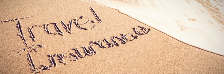 Travel Insurance text written on sand