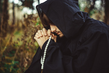 a monk in robes praying in the woods