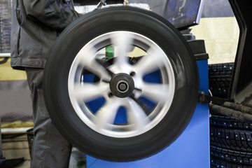 Process of balancing and fitting car tire wheel in motion, auto repair service, garage