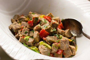 Salad with pieces of beef with vegetables under sauce