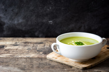 zucchini soup in bowl on wooden table and black background