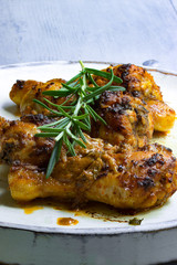 Hühnchenschenkel gebraten mit Rosmarin auf einem hellem Hintergrund