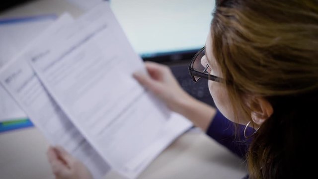 Businesswoman goes through documents very carefully