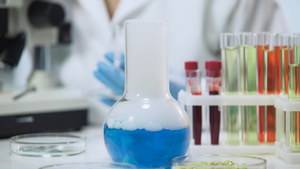 View of laboratory flask with evaporating liquid, chemical experiment, close-up