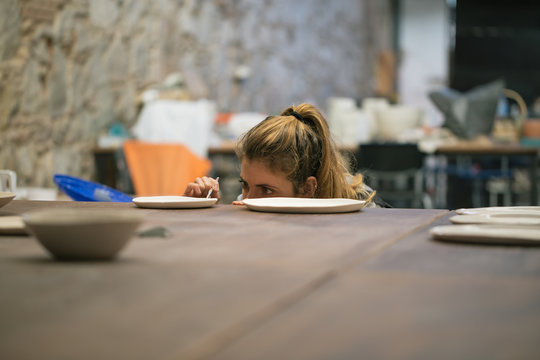 Diligent woman working on crockery creation