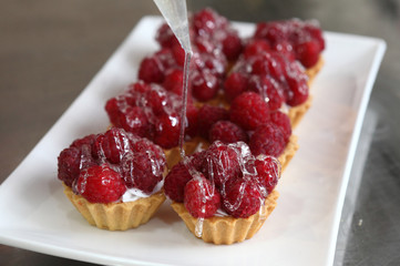 Filling the molds shortbread whipped cream and decoration of raspberries.Filled with sweet jelly.