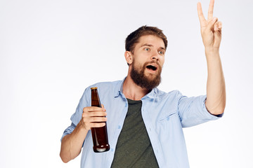 Man with a beard on a white isolated background holds a bottle of beer, alcohol, emotions
