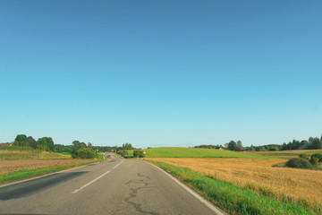 Fototapeta na wymiar Road, green and yellow field. Blue sky. Euro-trip