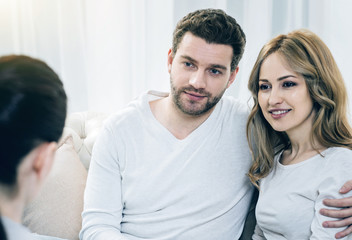 Together again. Happy joyful pleasant couple hugging each other and smiling while seeing the results of psychological therapy