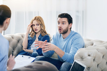 Family crisis. Emotional unhappy good looking man looking at the psychologist and complaining about...