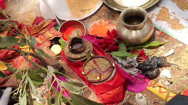 bride and groom pour oil on the accessories that are on the bedspread on the Indian wedding ceremony coconuts fruit rice
