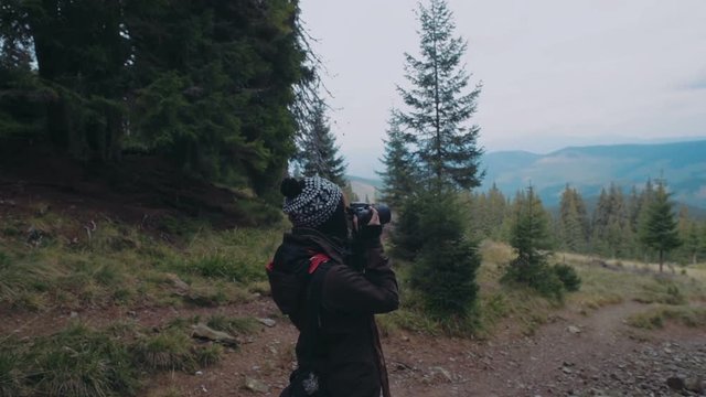 female photographer taking photos in mountains