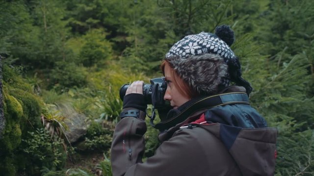 female photographer taking photos in mountains
