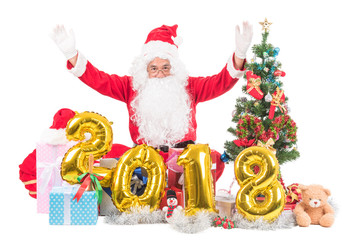 2018 happy new year Santa claus with christmas concept sitting among giftes, presents, dolls, christmas tree and xmas balloon, isolated on white background with clipping path