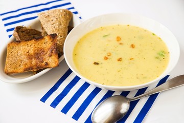 Dense vegetable soup,roasted bread, striped napkin.