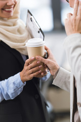 businesswoman giving coffee to colleague