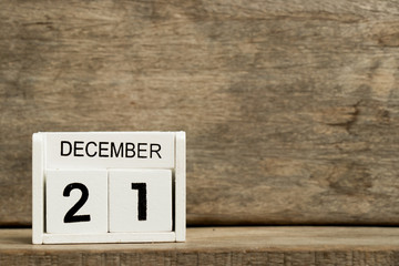 White block calendar present date 21 and month December on wood background