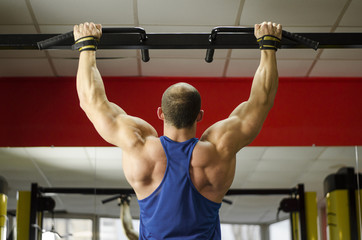 Naklejka premium Back view of strong male athlete with perfect muscles training, doing exercises