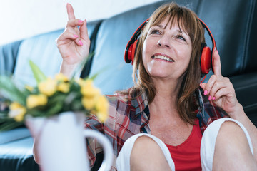 Happy mature woman listening to music
