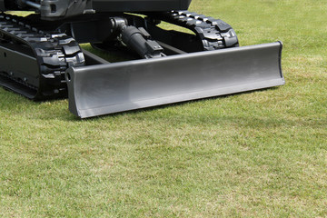 A Small Bulldozer Blade on the Front of an Excavator.