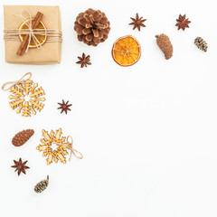 Christmas composition of wooden decoration, gift box and pine cones on white background. Flat lay, top view