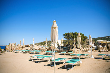 Fototapeta na wymiar sunloungers and umbrellas in Baja Sardinia, Italy