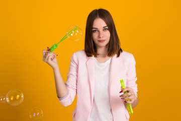 Young cute girl blows soap bubbles, isolated  