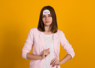 Obraz premium Young cute girl, sticker on a head, studio 